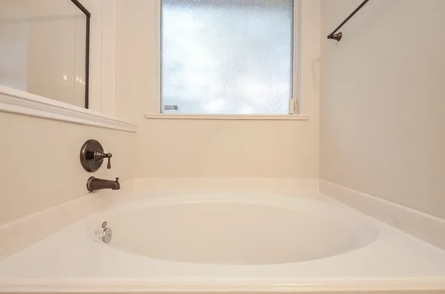 a white bath tub sitting next to a shower