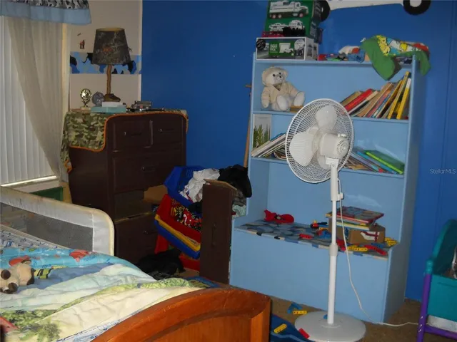 a bed sitting in a bedroom next to a window