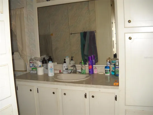 a kitchen with kitchen island granite countertop a table chairs and a wooden floor