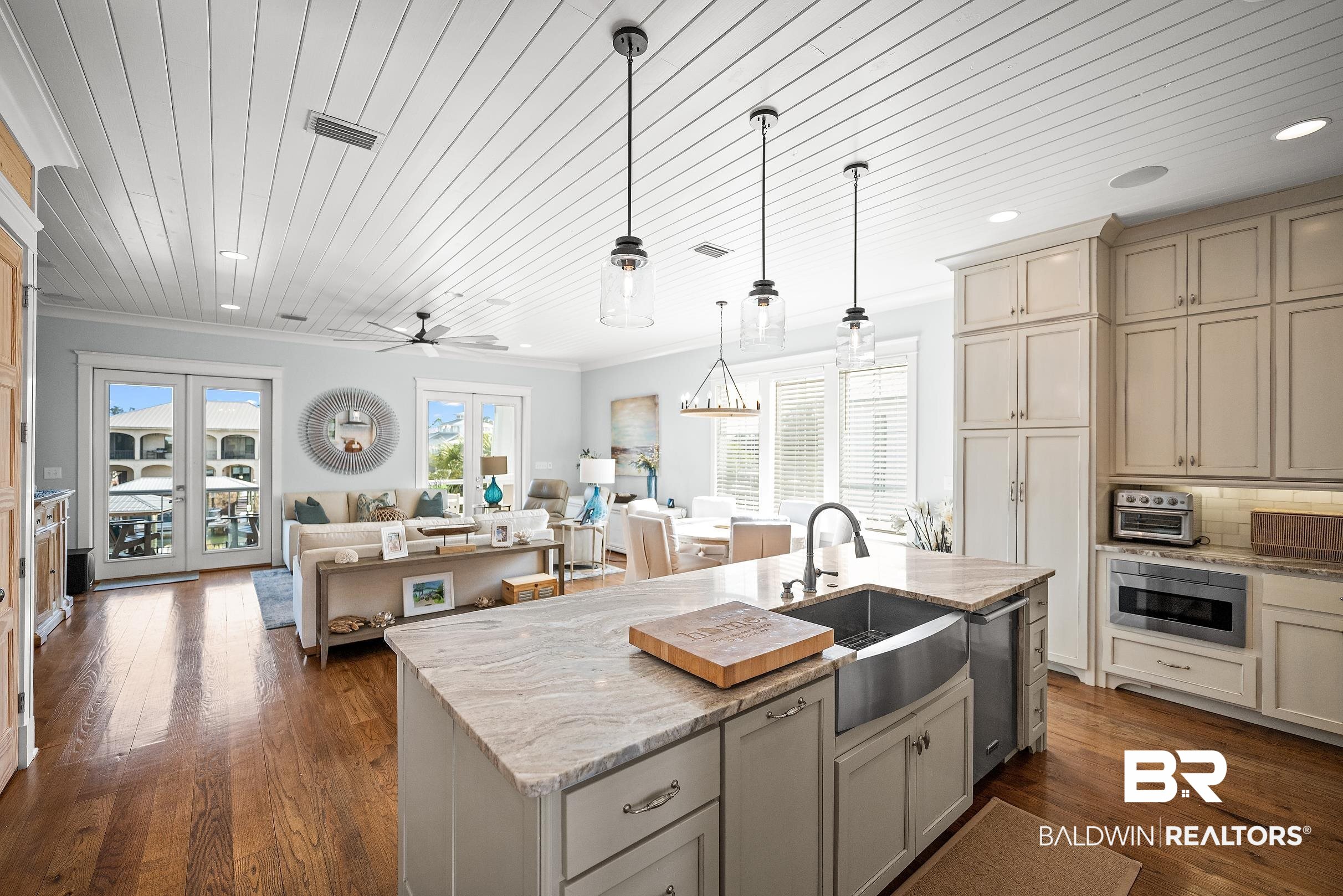 33186 Marlin Key Drive Orange Beach, AL 36561 - Photo 83 of 87 Kitchen with open floor plan, light stone counters, an island with sink, ceiling fan, and decorative light fixtures