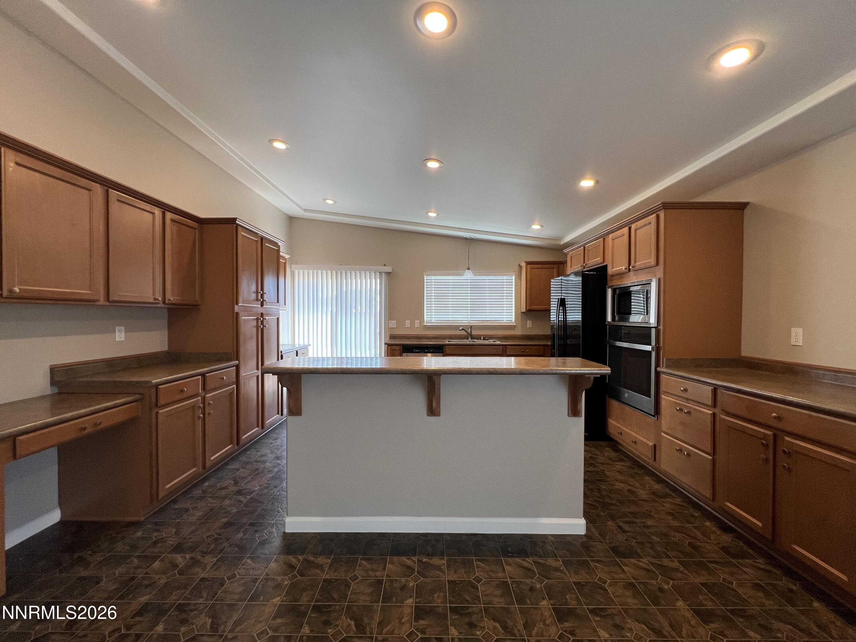 18406 Teddy Bear Court Reno, NV 89508 - Photo 7 of 44 a kitchen with stainless steel appliances kitchen island granite countertop a sink stove and refrigerator