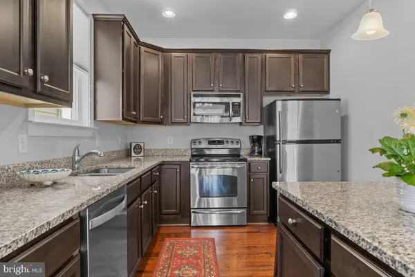 a kitchen with kitchen island granite countertop a sink stove and refrigerator