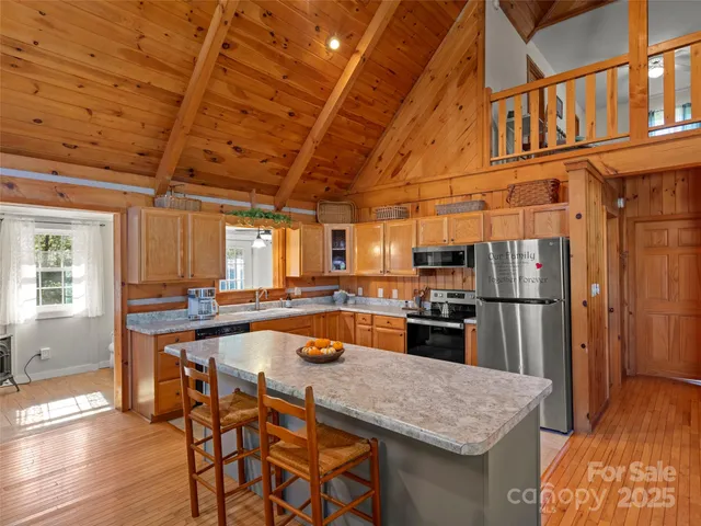 a kitchen with stainless steel appliances granite countertop a sink a stove and a wooden floors