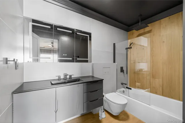 a bathroom with a double vanity sink toilet mirror and shower