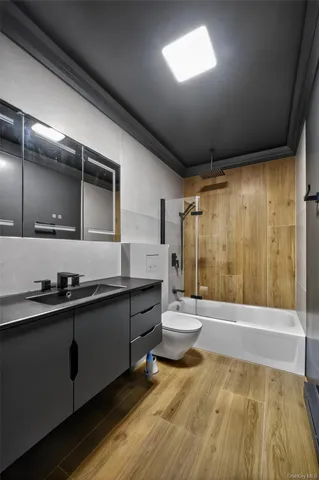 a bathroom with a sink a toilet a mirror and shower