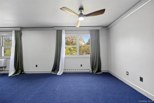 an empty room with ceiling fan and window