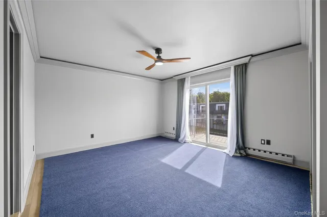 an empty room with ceiling fan and window