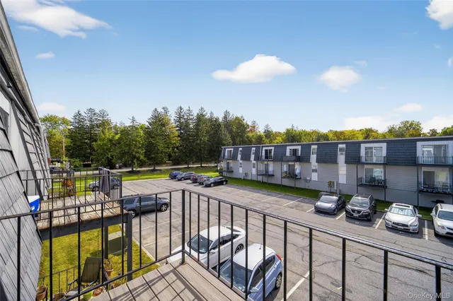 a view of a balcony with chairs and iron fence