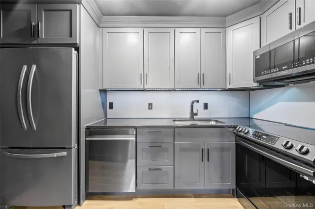 a kitchen with stainless steel appliances granite countertop a refrigerator stove and sink