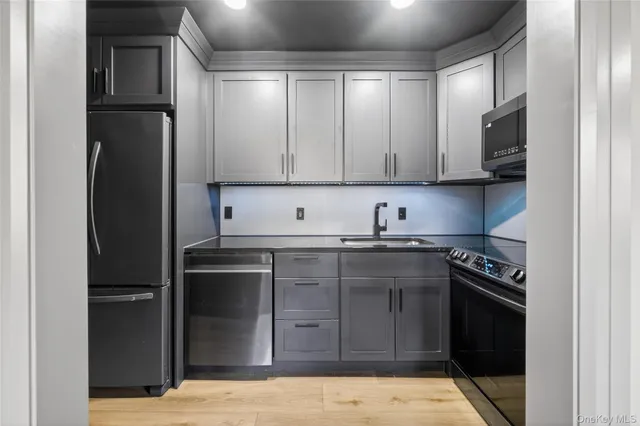 a kitchen with stainless steel appliances granite countertop a refrigerator and a stove top oven