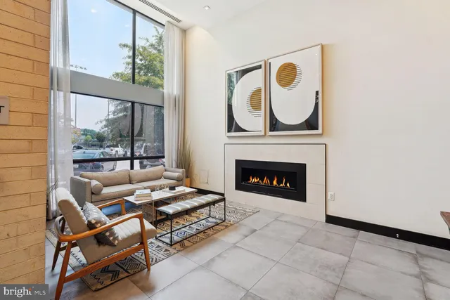 a living room with furniture a fireplace and a window