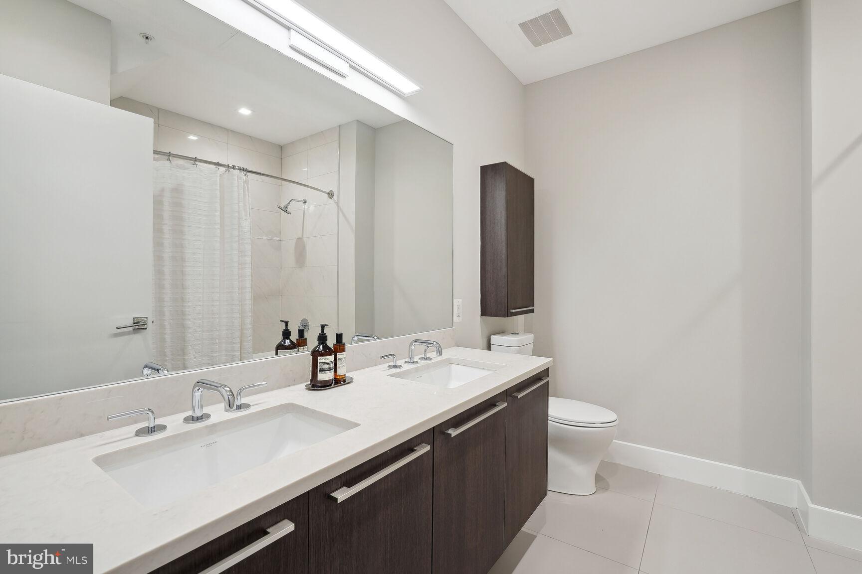 1628 11th Street Northwest, Unit 108 Washington, DC 20001 - Photo 21 of 44 a bathroom with a double vanity sink and a mirror