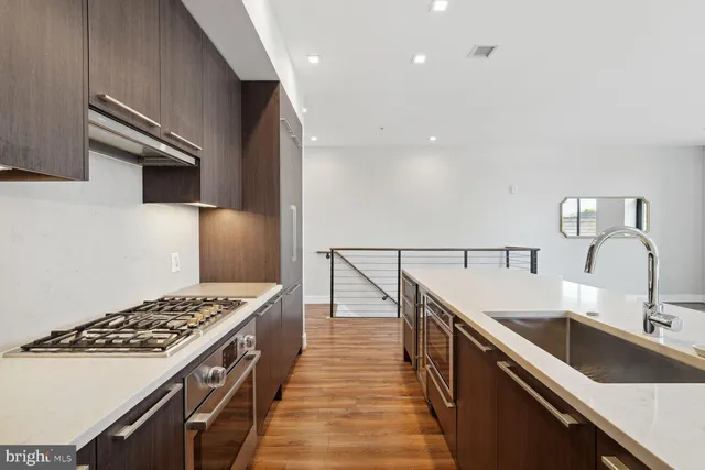 a kitchen with kitchen island a sink stove top oven and cabinets