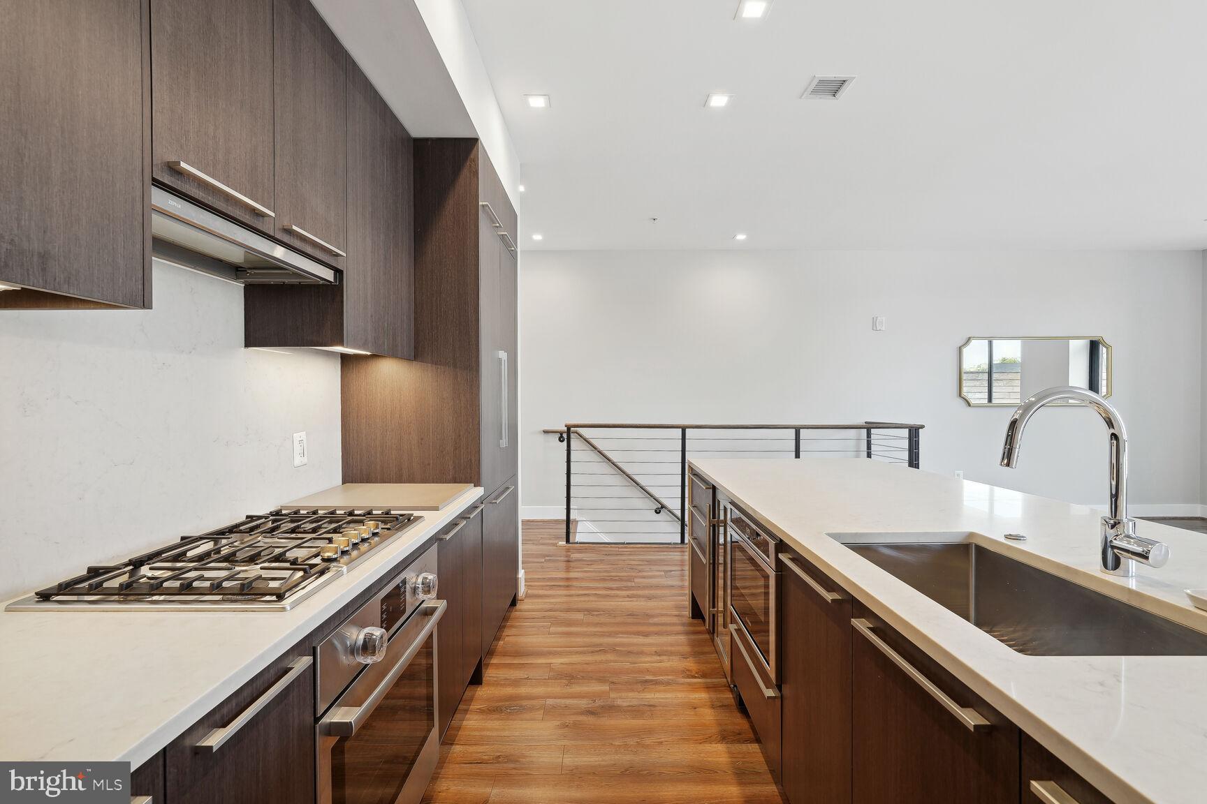 1628 11th Street Northwest, Unit 108 Washington, DC 20001 - Photo 9 of 44 a kitchen with kitchen island a sink stove top oven and cabinets
