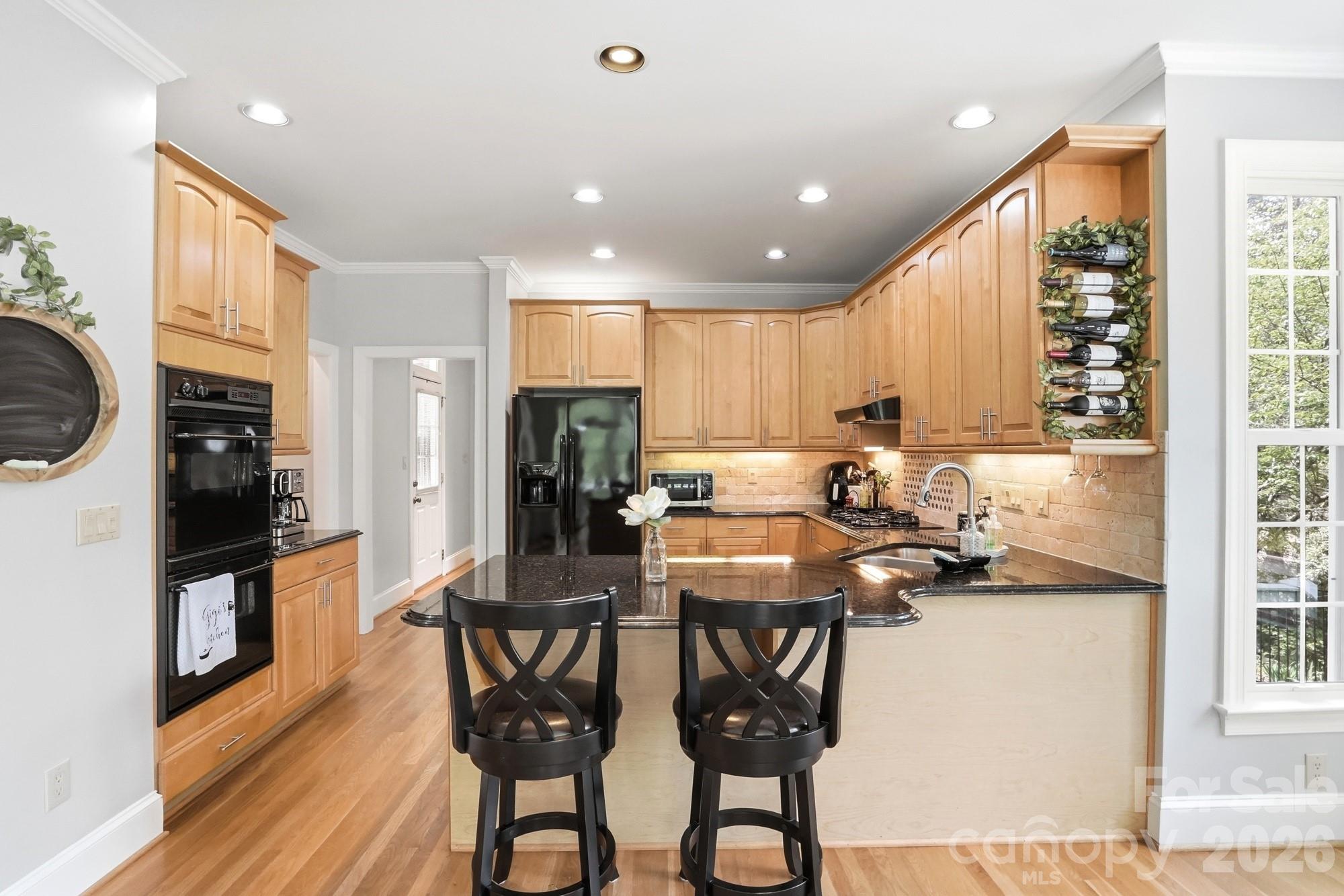 11078 Deep Cove Drive Tega Cay, SC 29708 - Photo 16 of 46 a kitchen with stainless steel appliances a dining table chairs and a refrigerator