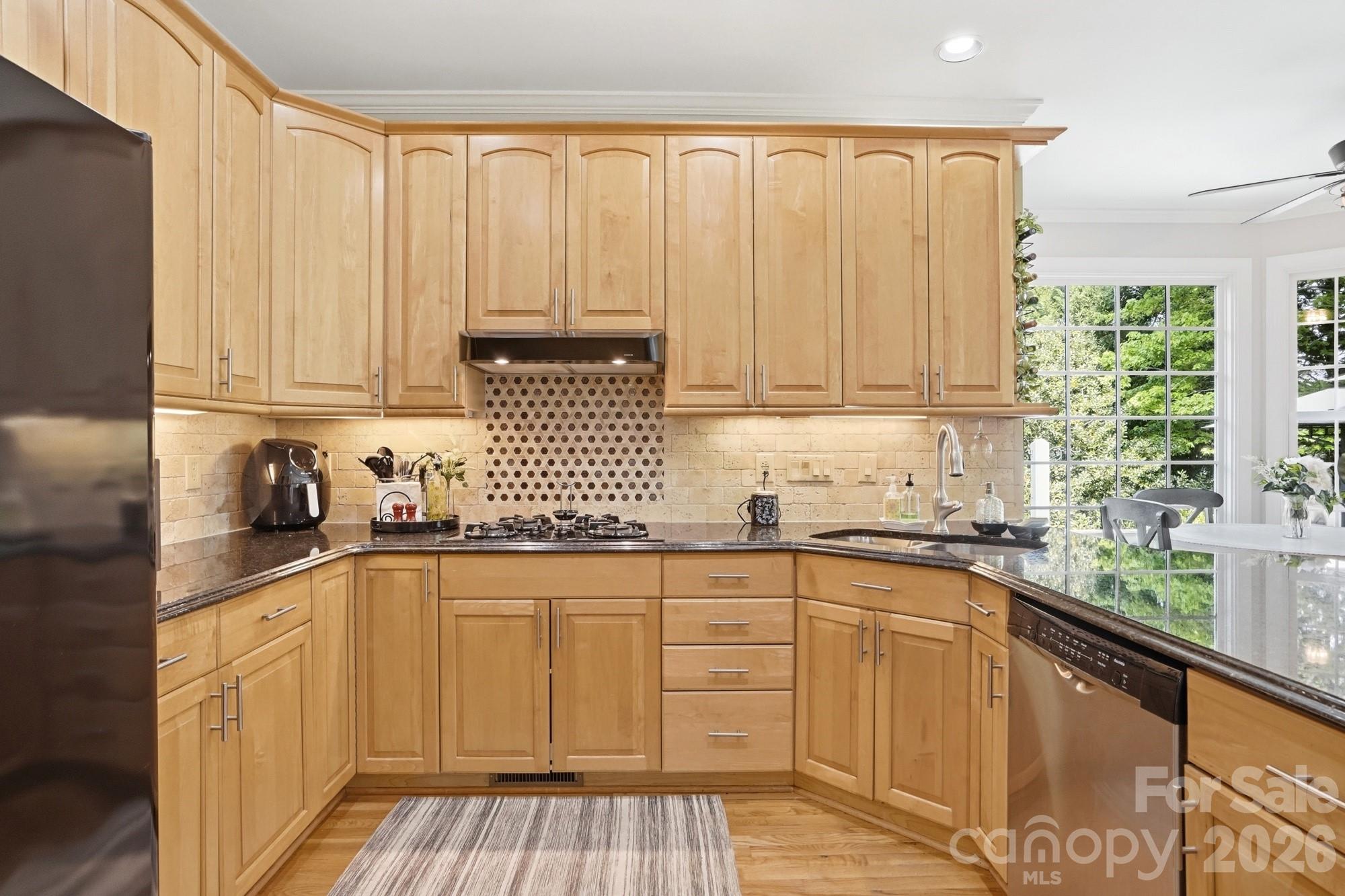 11078 Deep Cove Drive Tega Cay, SC 29708 - Photo 17 of 46 a kitchen with stainless steel appliances granite countertop white cabinets sink and dishwasher with wooden floor