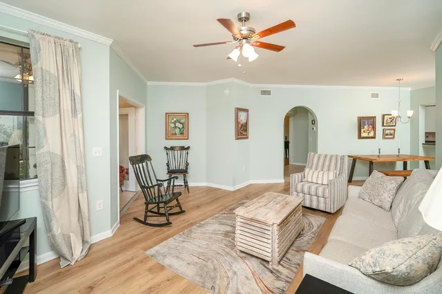 a living room with furniture a dining table and paintings on the wall