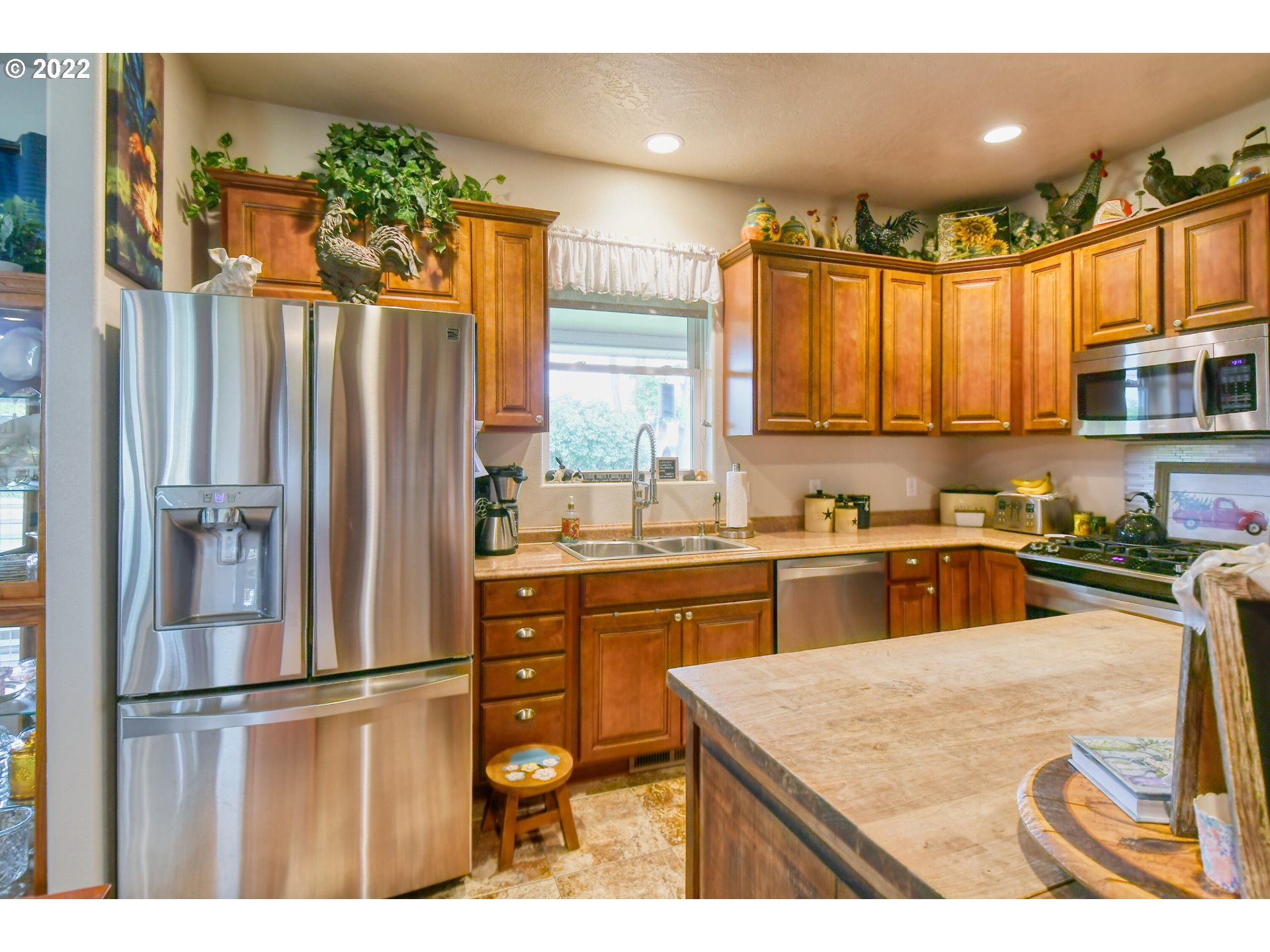 33104 Stage Gulch Road Stanfield, OR 97875 - Photo 8 of 32 a kitchen with stainless steel appliances granite countertop a refrigerator a sink dishwasher and white cabinets with wooden floor