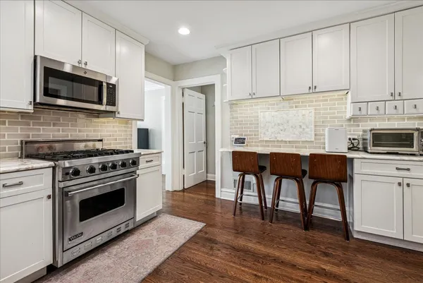 a kitchen with stainless steel appliances a stove a sink and a microwave