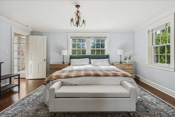 a spacious bedroom with a bed and wooden floor