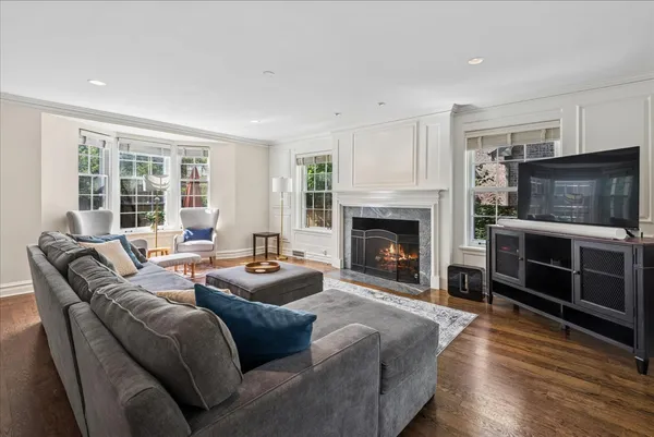 a living room with furniture a flat screen tv and a fireplace