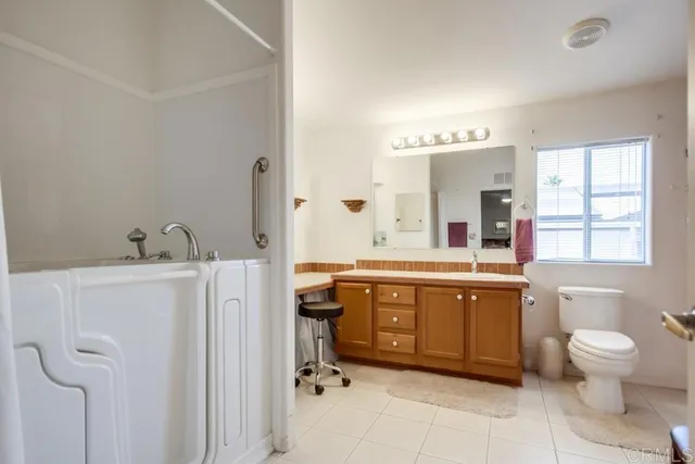 a spacious bathroom with a double vanity sink a mirror and a toilet