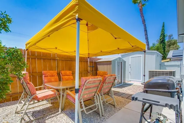 a view of a backyard with furniture and table under an umbrella