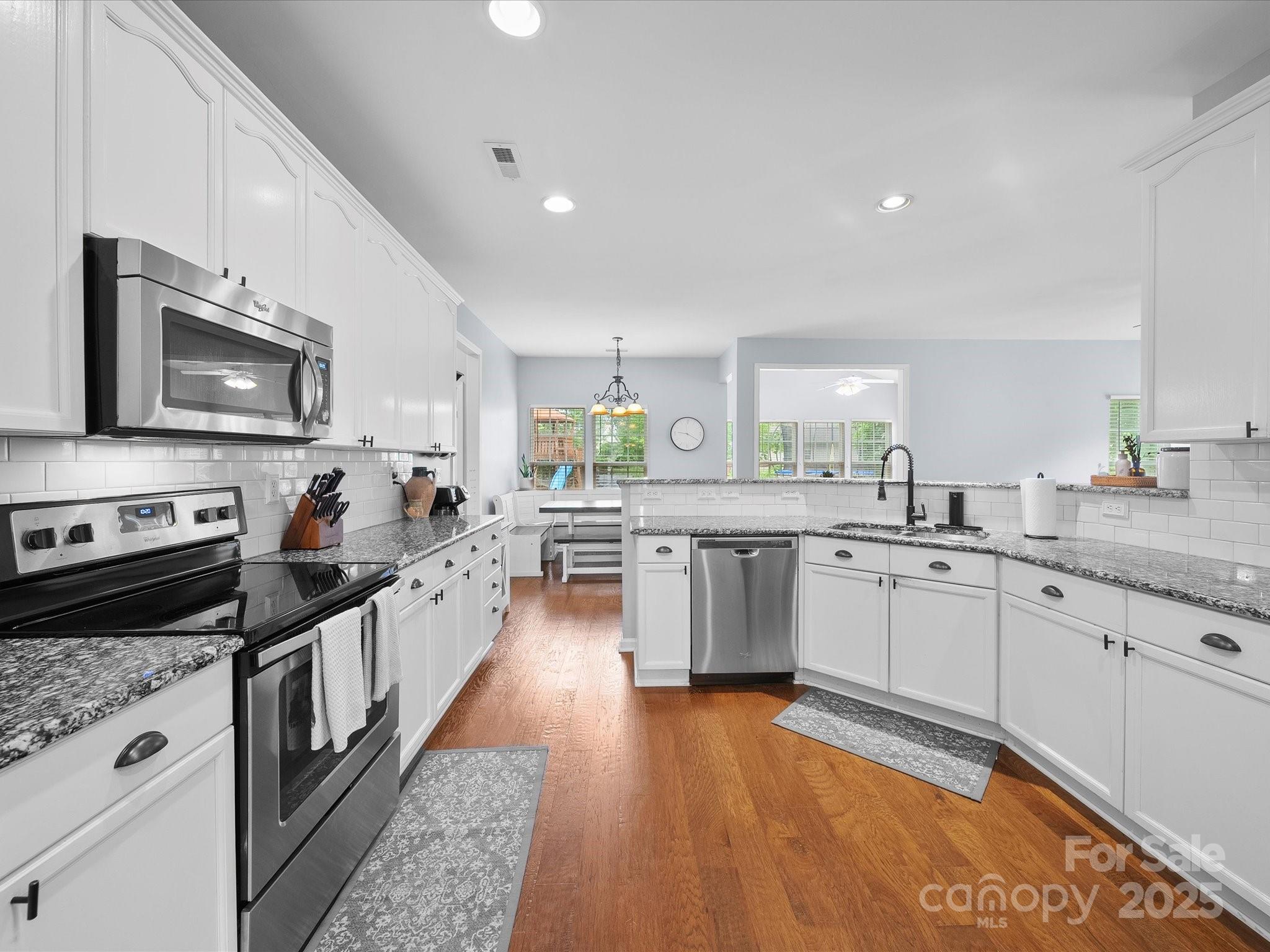 1151 Gower Street Fort Mill, SC 29708 - Photo 6 of 40 a large kitchen with stainless steel appliances lots of counter space and wooden floor