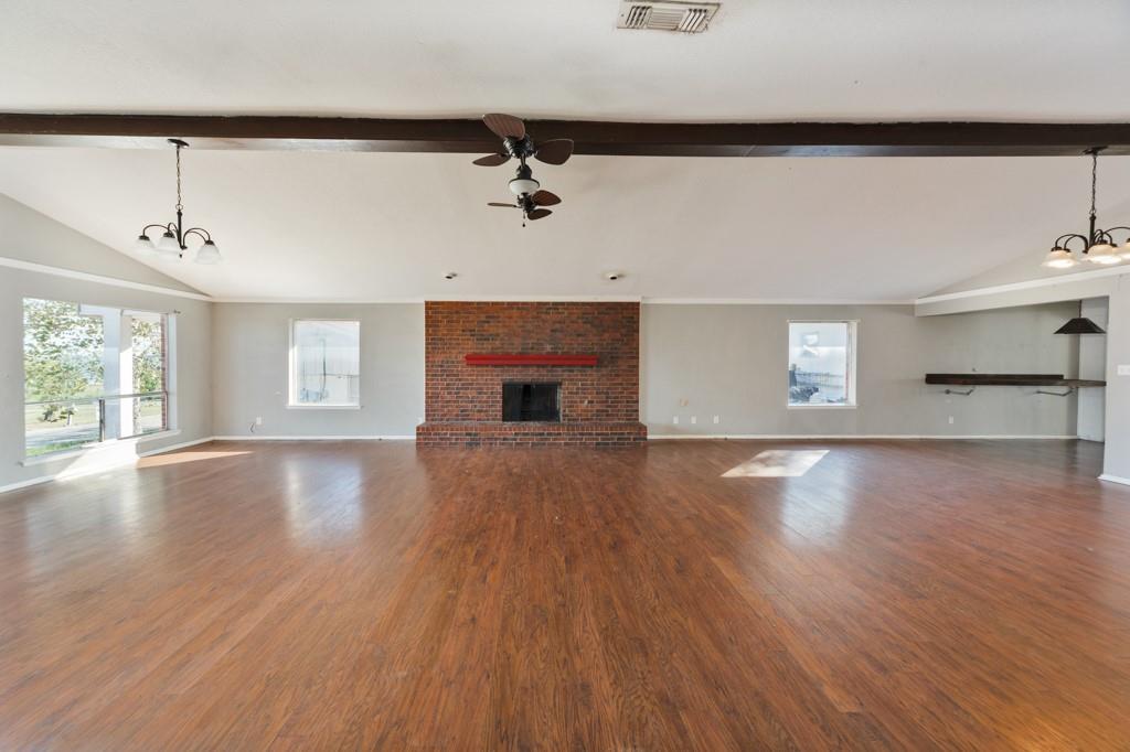 an empty room with windows and a fireplace