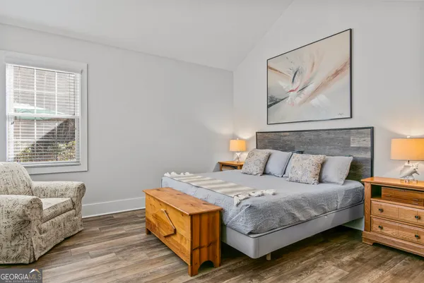 a bedroom with a bed and a couch with window