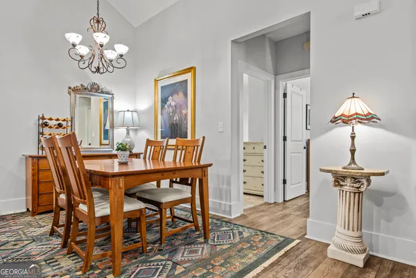 a dining room with furniture a chandelier and wooden floor