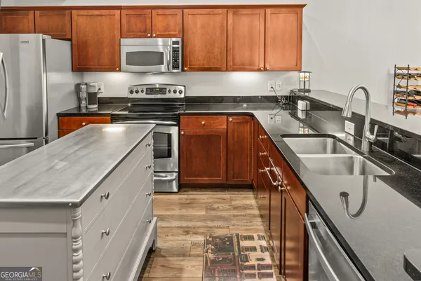 a kitchen with stainless steel appliances granite countertop a sink a stove and a refrigerator