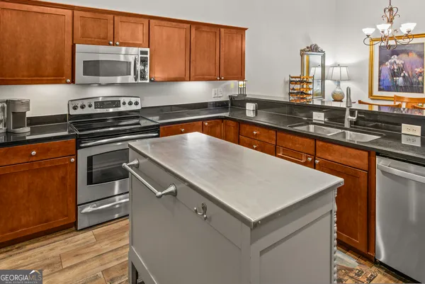 a kitchen with stainless steel appliances granite countertop a sink stove and microwave
