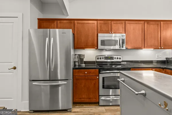 a kitchen with a refrigerator and a stove top oven