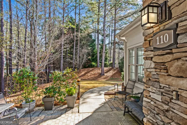 a front view of a house with a garden and trees