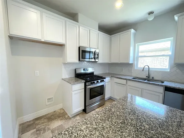 a kitchen with a stove a sink and a microwave