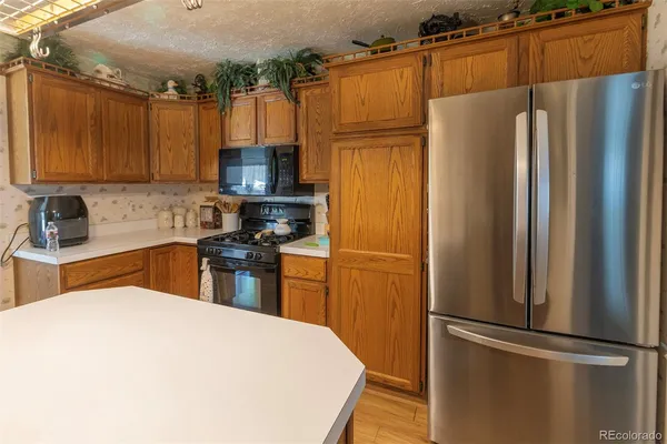 a kitchen with stainless steel appliances granite countertop a refrigerator and a sink