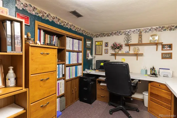 a view of a workspace with furniture and a window