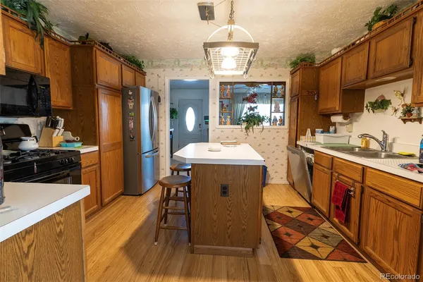 a kitchen with stainless steel appliances a sink stove refrigerator and cabinets