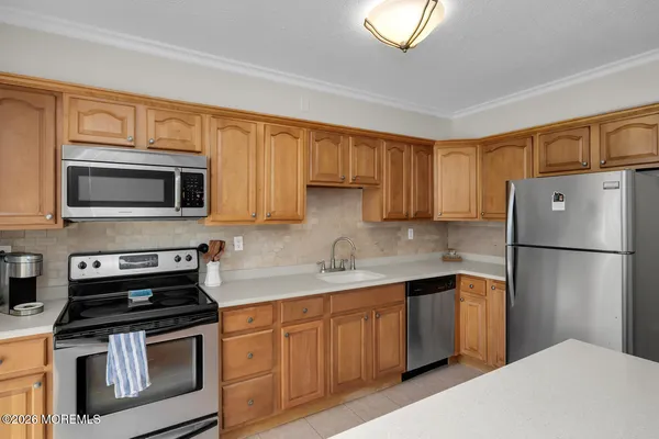 a view of an empty room and kitchen
