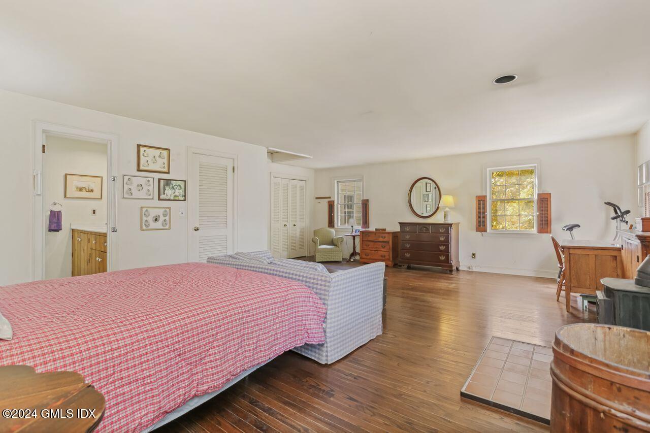 242 Taconic Road Greenwich, CT 06831 - Photo 22 of 37 a bed room with a bed mirror and a chair