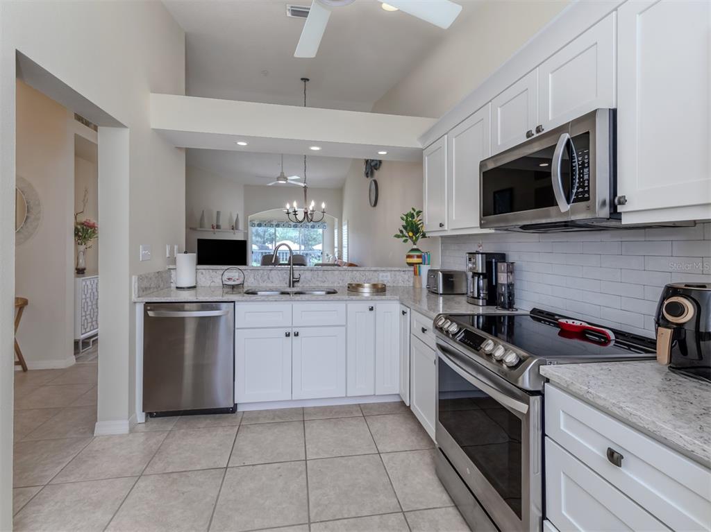 901 Addington Court, Unit 203 Venice, FL 34293 - Photo 12 of 61 a kitchen with stainless steel appliances granite countertop white cabinets a sink a stove and a refrigerator