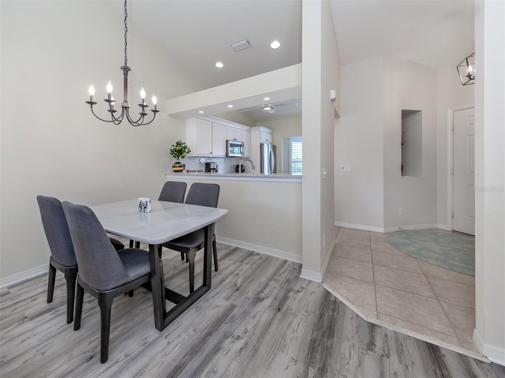 901 Addington Court, Unit 203 Venice, FL 34293 - Photo 14 of 61 a view of a dining room with furniture wooden floor and a chandelier