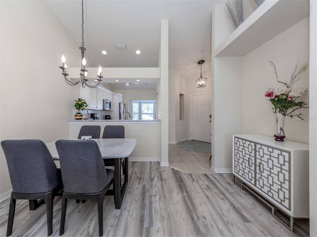 901 Addington Court, Unit 203 Venice, FL 34293 - Photo 15 of 61 a view of a dining room with furniture and wooden floor