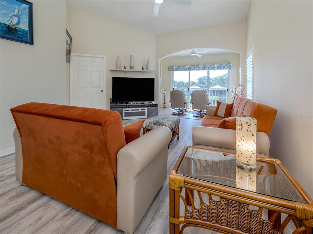 901 Addington Court, Unit 203 Venice, FL 34293 - Photo 17 of 61 a living room with furniture a flat screen tv and a fireplace