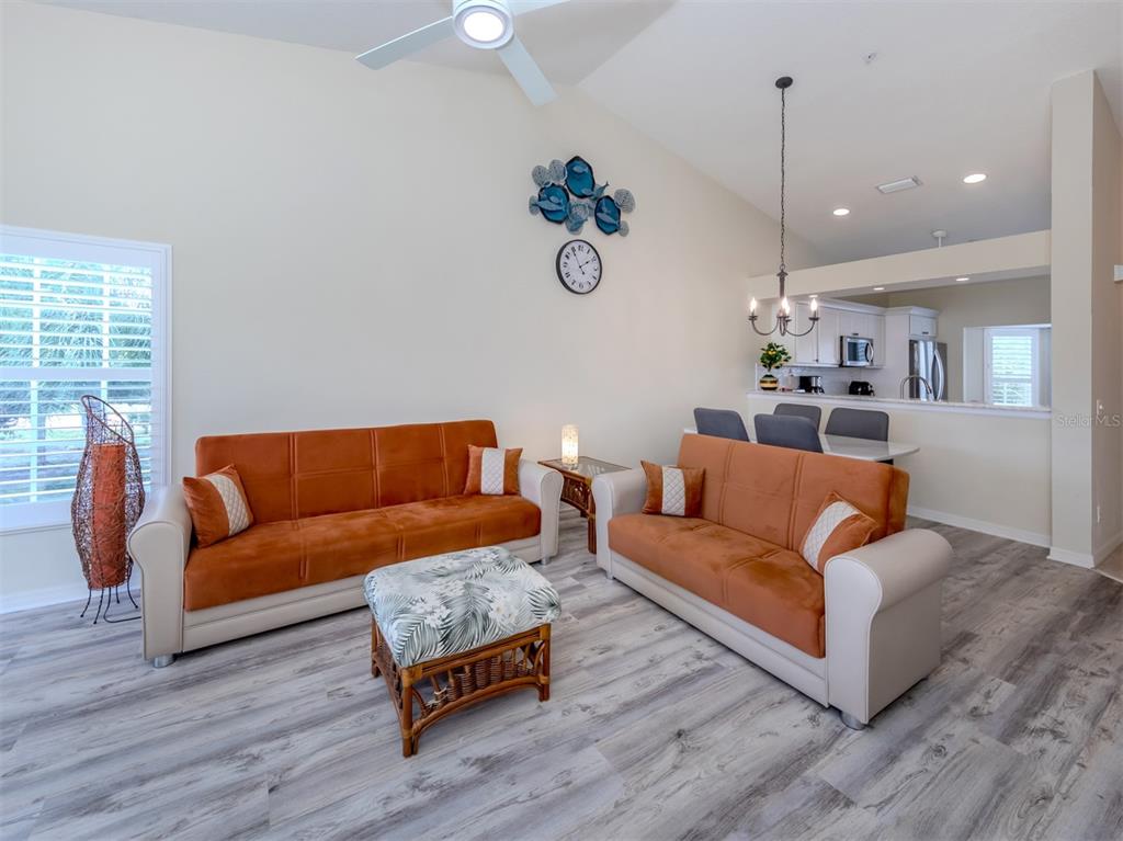 901 Addington Court, Unit 203 Venice, FL 34293 - Photo 18 of 61 a living room with furniture kitchen view and a wooden floor