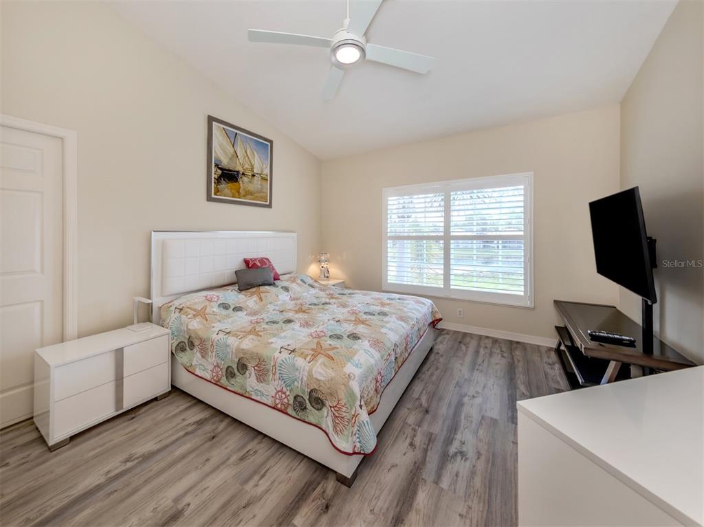 901 Addington Court, Unit 203 Venice, FL 34293 - Photo 24 of 61 a bedroom with a bed and a flat screen tv