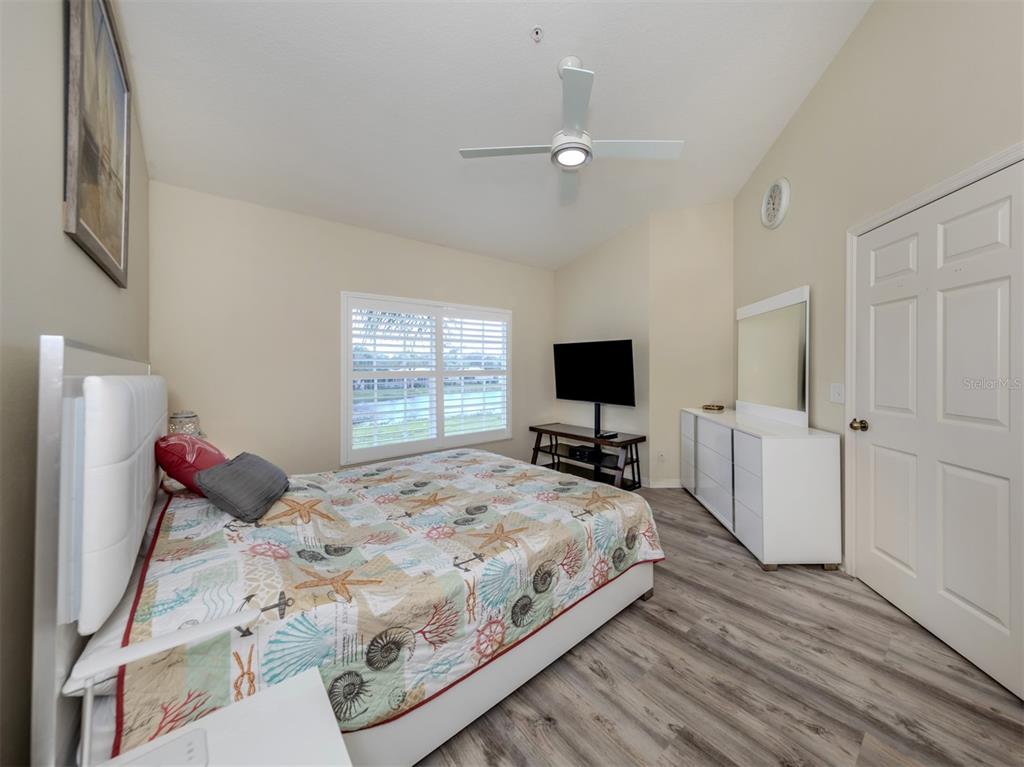 901 Addington Court, Unit 203 Venice, FL 34293 - Photo 25 of 61 a bedroom with a bed and a flat screen tv