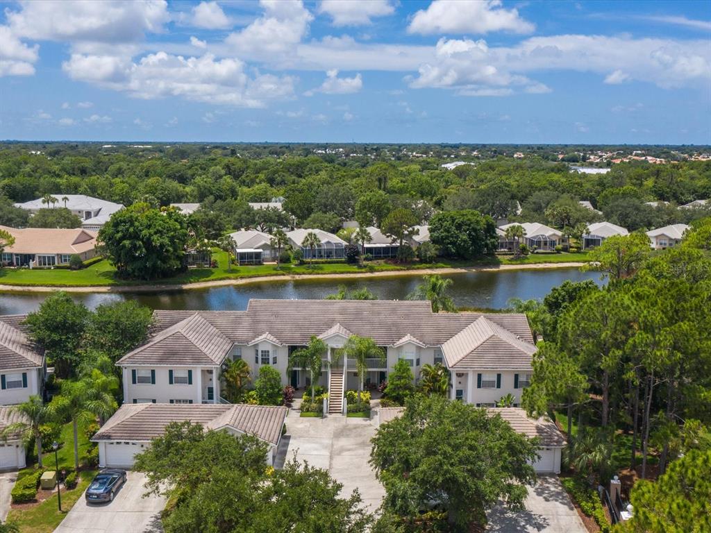 901 Addington Court, Unit 203 Venice, FL 34293 - Photo 32 of 61 an aerial view of a house with a garden and lake view