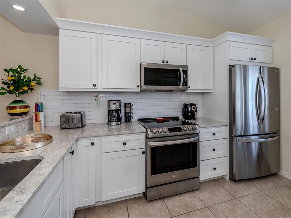 901 Addington Court, Unit 203 Venice, FL 34293 - Photo 8 of 61 a kitchen with stainless steel appliances granite countertop a refrigerator sink and stove